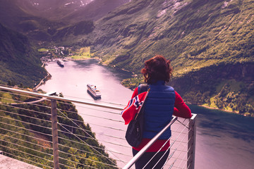 Tourist over Geirangerfjord with norwegian flag