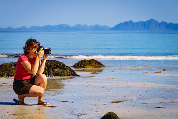Woman take photo on beach, Lofoten Norway