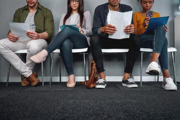 Diverse candidates sitting in queue with their cv at office expecting their turn for interview -...