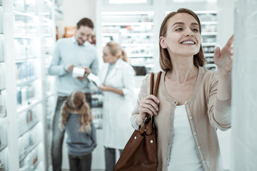 A woman selecting pills while the pharmacologist advising her family.