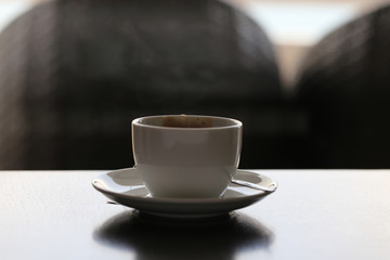 Tea bag in  cup with spoon and sauce. White cereamic tea cup  on wood table with dark scene