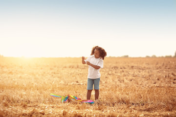 Little African-American girl flying kite outdoors