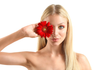 Obraz na płótnie Canvas Beautiful young woman with gerbera flower on white background