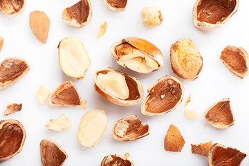 Hazelnuts crushed into pieces, on a white background, flat lay - creative background