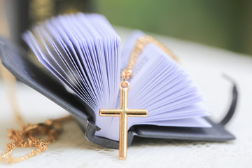 Gold Christ cross lace with holy bible, black cover. European religion conceptual for Christian...