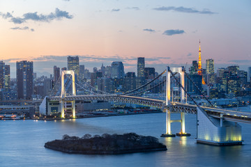 Sunset of Tokyo Bay with Rainbow Bridge in Odaiba city skyline.