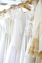Wedding white gown for bride hanged in costume showroom for marriage or wedding reception. White...