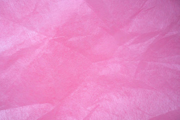 Pink crumpled wrapping paper background and texture. Tender pink background creates a romantic mood