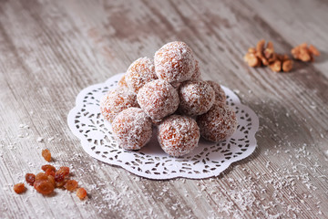 Appetizing energy balls walnuts raisins dried apricots coconut flakes on a paper napkin on a table