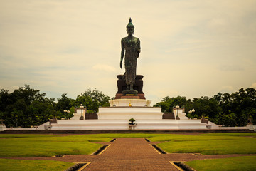 Obraz premium Standing buddha for worship in Phutthamonthon Park with sunset sky and reflective light,beautiful background