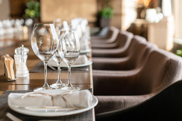 Wine glasses in the foreground. Wedding Banquet or gala dinner. The chairs and table for guests,...