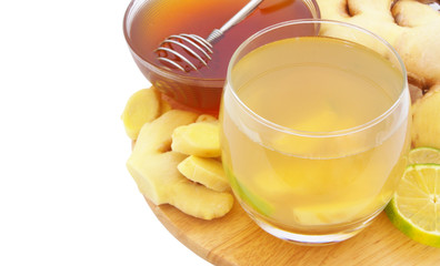 Hot ginger tea glass with lime and honey on board isolated on white