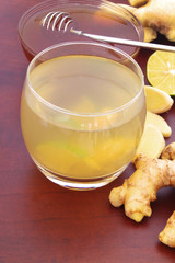 Glass of ginger tea with lime and honey on table