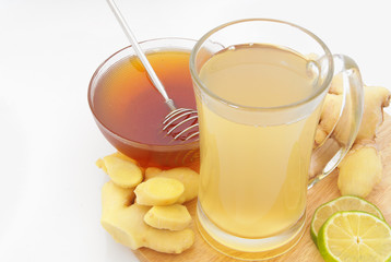 Ginger tea cup, lime and honey on wooden board