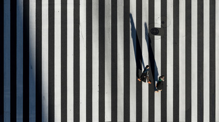 Aerial view of people passing crosswalk in the downtown street.