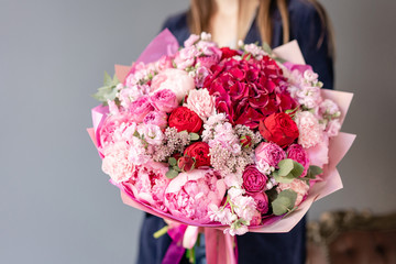 Pink peonies and red hydrangea. Beautiful bouquet of mixed flowers in woman hand. Floral shop concept . Handsome fresh bouquet. Flowers delivery. Red and pink color.