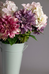 Silk flowers in tall metal vase