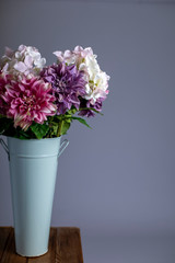 Silk flowers in a tall metal vase
