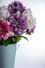 Silk flowers in tall metal vase