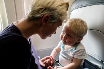 Mom spending time with her one year old baby boy during flight