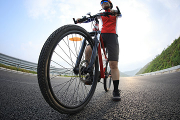 Fototapeta na wymiar Woman cyclist riding mountain bike on highway