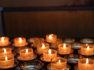 lit tea light candles in catholic church