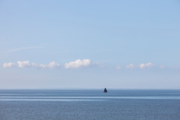 lonely sailing vessel on blue water of wadden sea in the netherlands