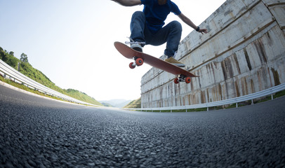 Fototapeta na wymiar Skateboarder skateboarding on highway road