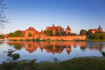 Naklejka na ściany i meble Malbork castle over the Nogat river at sunset, Poland