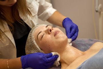 Obraz na płótnie Canvas Beauty Clinic.woman gets a professional facial procedure. Beautician makes massage on a woman's face. face renewal