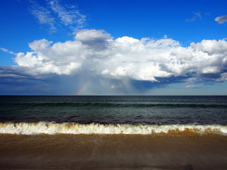 Regenbogen über dem Meer: Aufziehende Regenwolke