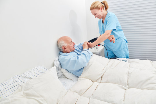 Nurse controls blood pressure of senior