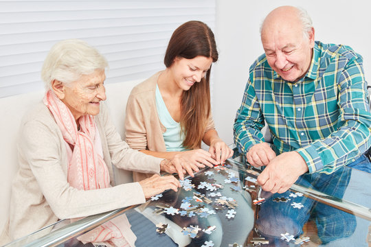 Senior couple playing jigsaw puzzle against dementia
