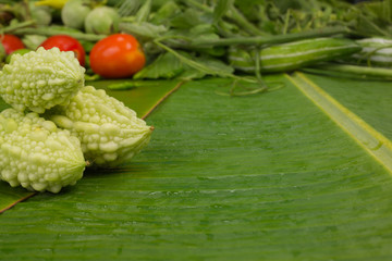 World Food Day concept, bitter gourd and other vegetables placed on a green banana leaf.