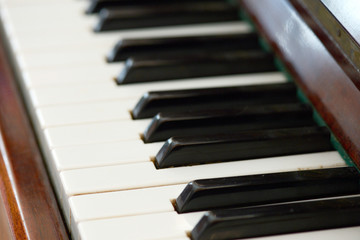Fototapeta premium Old brown piano close-up. The keys of an old vintage piano