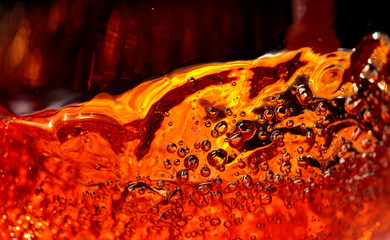 Alcoholic drink on a dark background, abstract splashing.