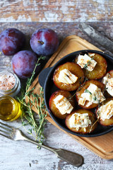 Keto snack. Baked plums with feta cheese and thyme. Keto friendly. Selective focus. Macro.