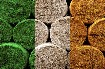 Ireland flag on the surface of a stack of hay rolls.
