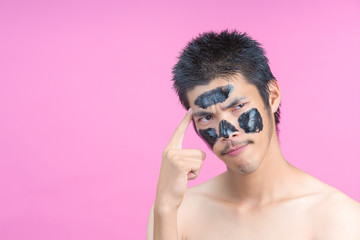 Handsome men who apply black cosmetics on their faces, showing various postures with a pink background.