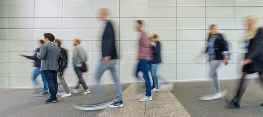 Anonymous blurred business people are walking around on a modern trade fair