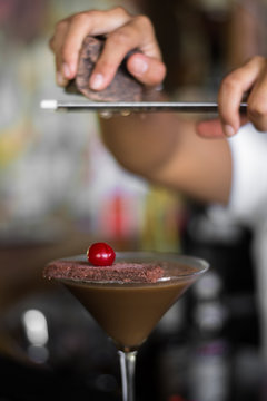 grating chocolate on top of a cocktail