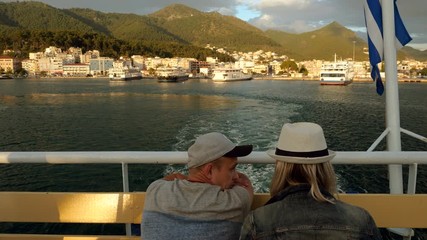A man and woman in love looking at coast from the deck of a cruise ship sailing the Mediterranean sea. Greece. 4K
