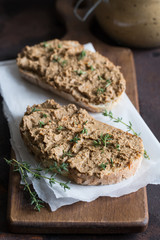 Fresh homemade chicken liver pate. Chicken liver pate on bread and in jar on a dark background