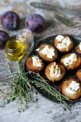 Baked plums with feta cheese and thyme. Keto friendly. Selective focus. Macro.