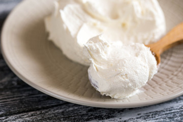 Fresh homemade mascarpone. Traditional Mascarpone cheese in wooden spoon
