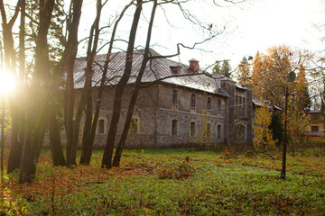Old stone house stands in autumn park on a sunny day