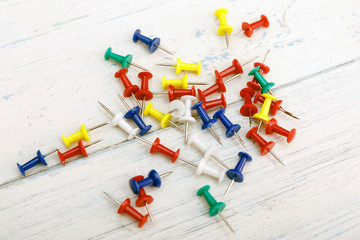 Colorful Thumbtack on white wooden background. Set of multicoloured Thumb Pins also called Push Pins which is used to pin notes to the notice board.