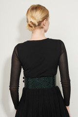 Cropped back view shot of a blond girl, posing on a white background. She is wearing black gown...