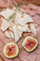Figs, cured sheep cheese (manchego type) and thyme. With rustic look on brown paper.