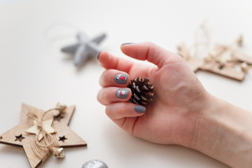 female hands with christmas deer manicure on the finger nails